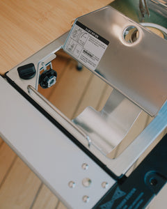 Kovea table stove in an IGT frame with the top plate lifted to show the gas connection