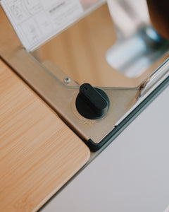 Close-up of the Kovea table stove control knob beside a bamboo tabletop