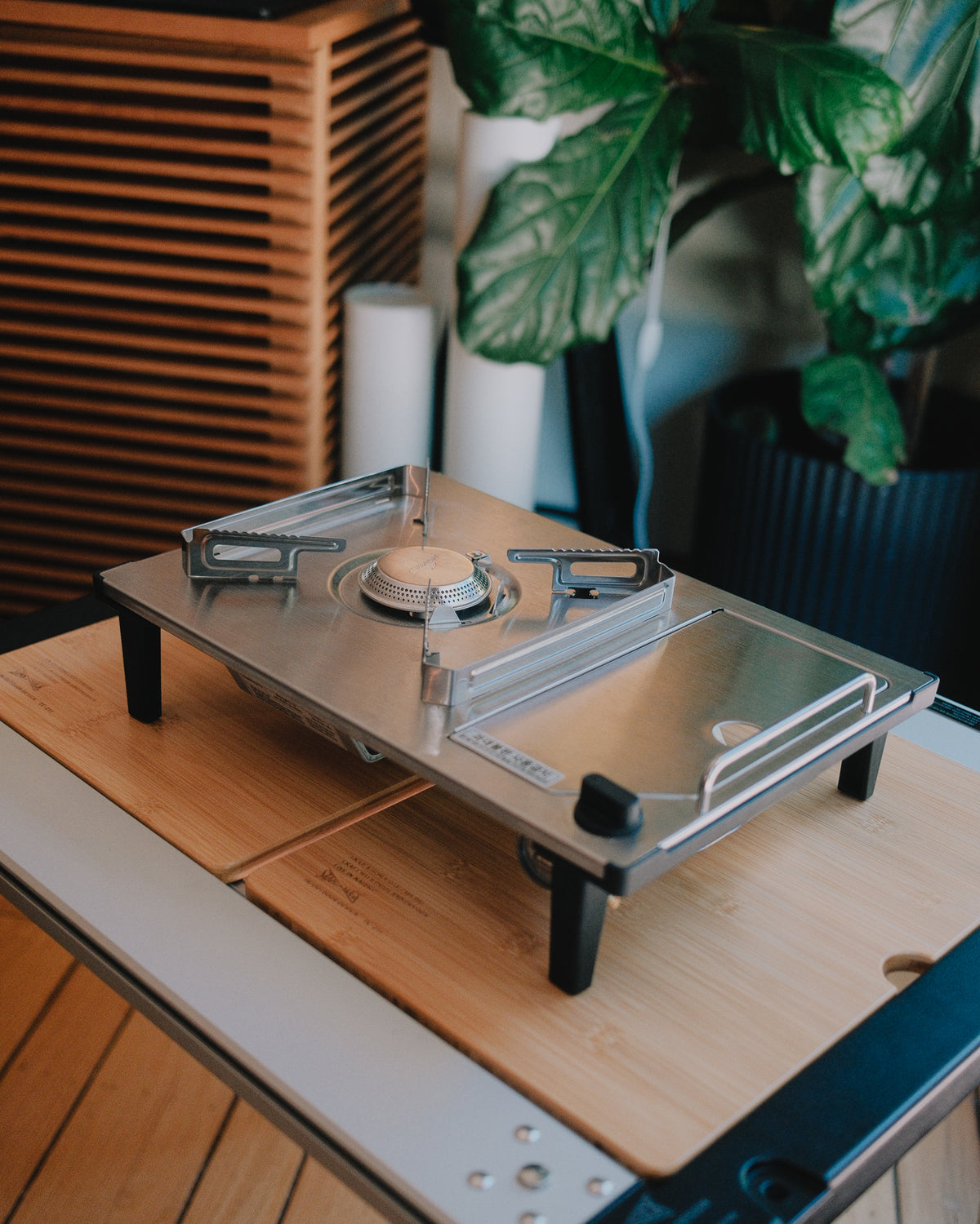 Kovea Portable IGT Table Stove standing on its legs on a bamboo IGT table